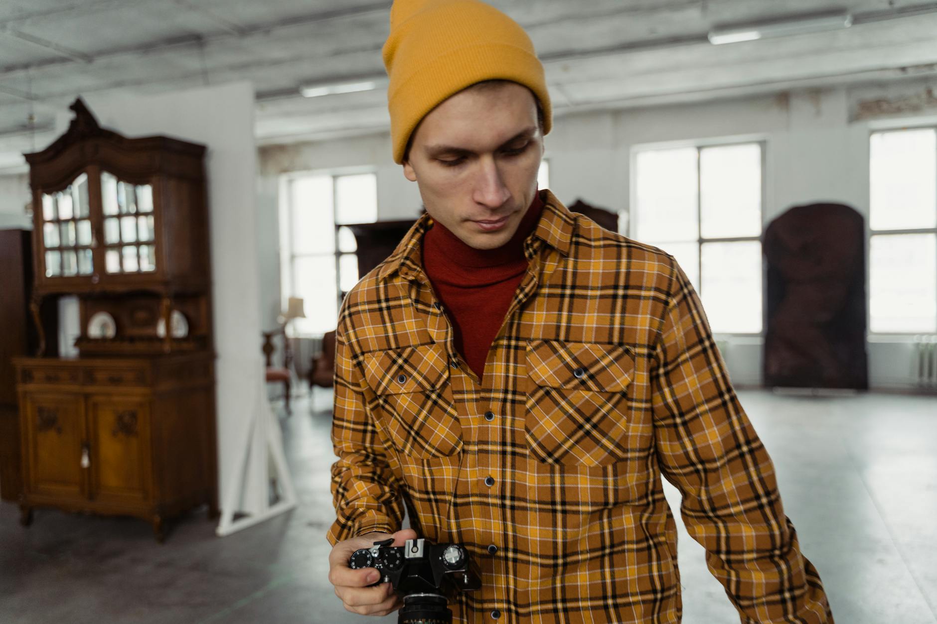 Fotograf w starej pracowni robi zdjęcie w żółtej czapce beanie
