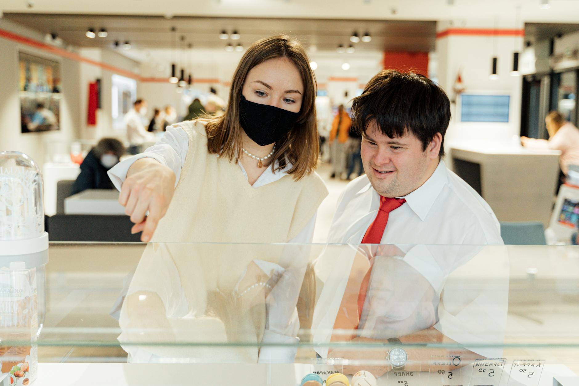 Kobieta w maseczce i mężczyzna przy ladzie w przytulnej kawiarni