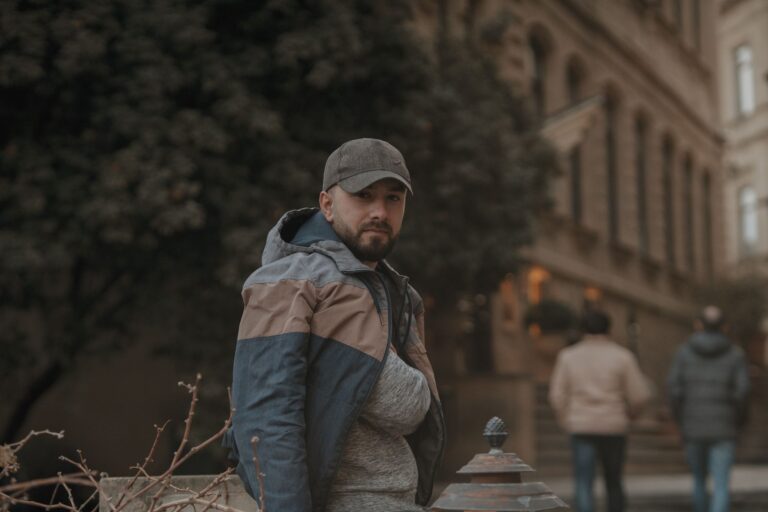 Mężczyzna w czapce i kurtce na miejskiej ulicy